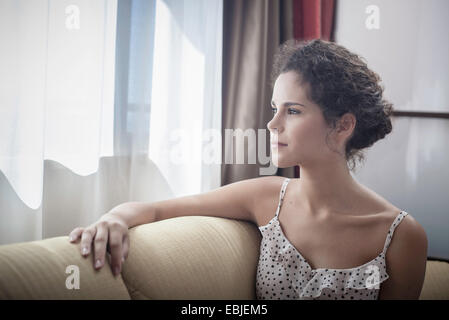 Junge Frau aus Fenster Stockfoto