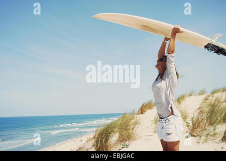Frau mit Surfbrett am Strand, Lacanau, Frankreich Stockfoto