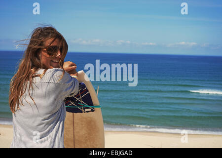 Frau mit Surfbrett am Strand, Lacanau, Frankreich Stockfoto