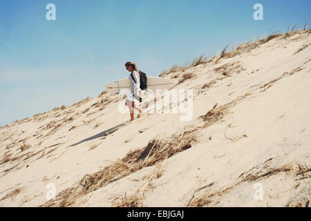 Frau mit Surfbrett am Strand, Lacanau, Frankreich Stockfoto