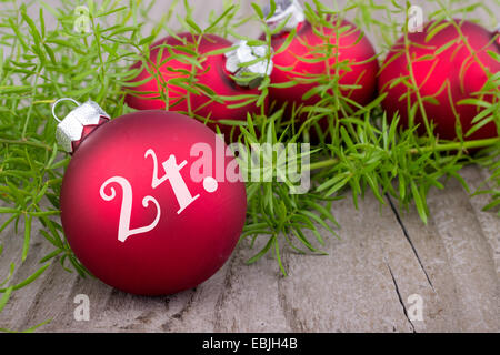 Rote Weihnachtskugeln mit grünen Zweig und Ziffer vierundzwanzigsten Stockfoto