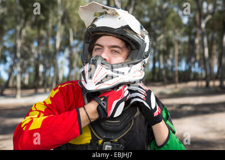 Motocross Motorrad Konkurrent Befestigung Helm im Wald Stockfoto