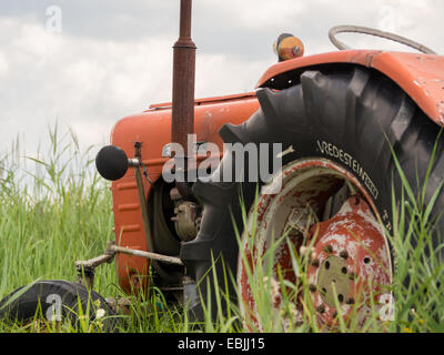 Nahaufnahme von einem alten rostigen Traktor in einem Feld in Weerribben Stockfoto