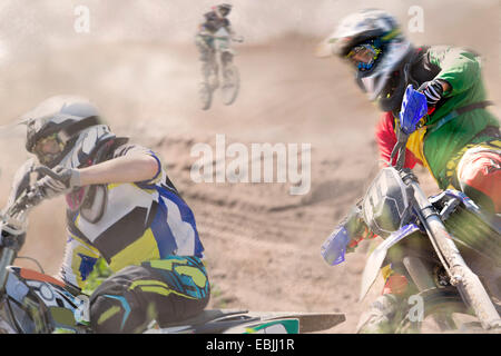 Drei junge männliche Motocross-Fahrer, die auf staubigen Track racing Stockfoto