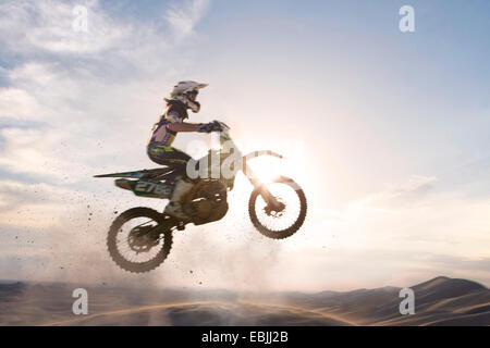 Silhouette, jungen männlichen Motocross Racer über Schlamm Track springen Stockfoto