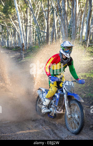 Junge männliche Motocross Racer durch Waldweg Stockfoto