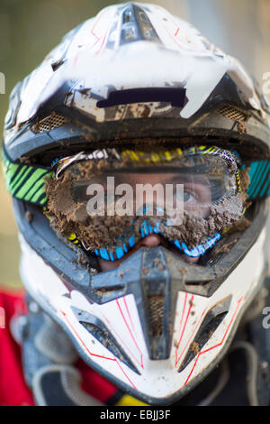 Porträt des männlichen Motocross Racer trägt schlammigen Helm und Brille hautnah Stockfoto