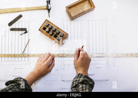 Händen der junge Handwerkerin Blaupause im Rohr Orgelwerkstatt messen Stockfoto