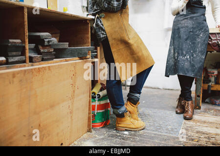 Blick auf zwei junge Handwerkerinnen in Rohr Orgelwerkstatt beschnitten Stockfoto