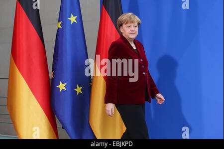 Berlin, Deutschland. 2. Februar 2014. Bundeskanzlerin Angela Merkel geht vorbei an den deutschen und EU-Flaggen während der Übergabe des 4. Zwischenbericht von der nationalen Plattform elektrische Mobilität (NPE) im Bundeskanzleramt in Berlin, Deutschland, 2. Februar 2014. Foto: WOLFGANG KUMM/Dpa/Alamy Live News Stockfoto