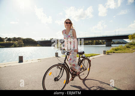 Junge Frau, Radfahren entlang der Flussufer, Donauinsel, Wien, Österreich Stockfoto