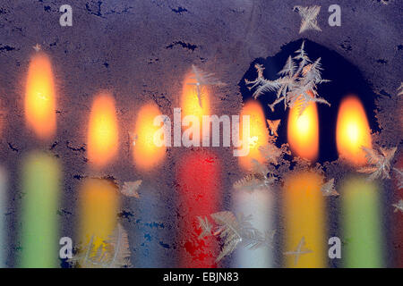 Eisblumen am Fenster im Kerzenschein Stockfoto