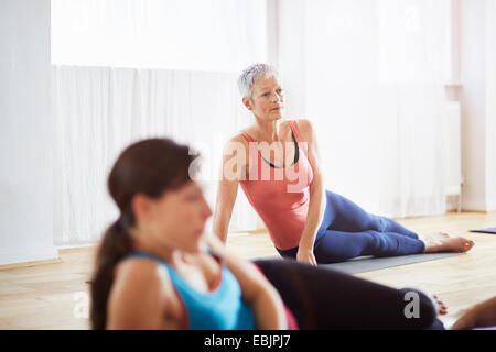 Zwei Frauen liegen auf der Seite in Pilates-Klasse Stockfoto