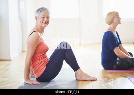 Porträt von Reife Frau sitzen auf Boden in Pilates-Klasse Stockfoto