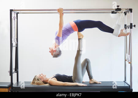 Zwei Reife Frauen praktizieren Pilates auf Trapez-Tisch in Pilates-Fitness-Studio Stockfoto