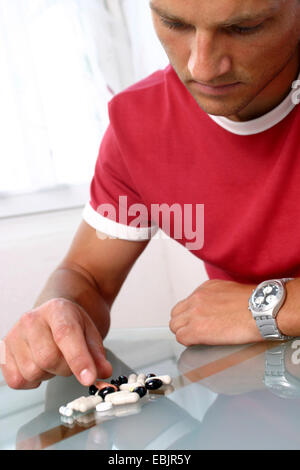 junger Mann nehmen Pillen Stockfoto