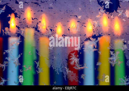 Eisblumen am Fenster im Kerzenschein Stockfoto
