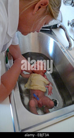 eines Tages alte Baby gebadet wird von einer Krankenschwester Stockfoto