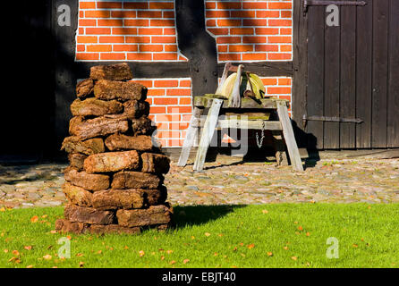 Torf-Stack und Schleifscheibe vor einer Scheune im Freilichtmuseum Osterholz-Scharmbeck, Deutschland, Niedersachsen Stockfoto