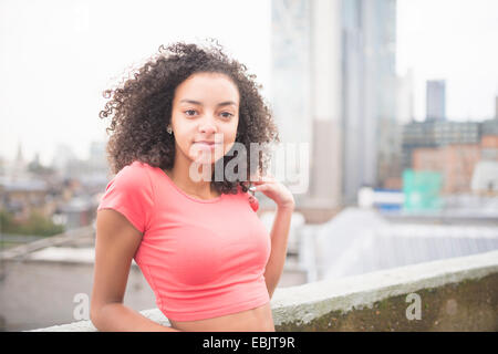Junge Frau, die Wand gelehnt Stockfoto