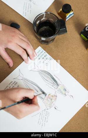 Junge Womans Hände malen Modedesign auf Arbeitstisch Stockfoto