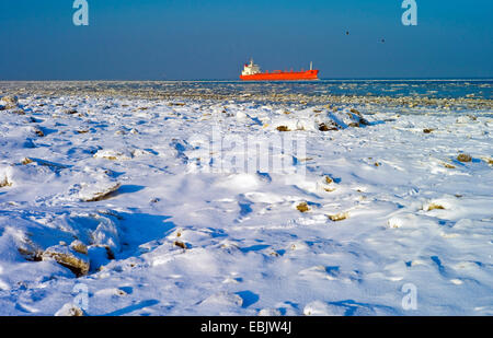 Driften Eis an Elbe, Frachtschiff im Hintergrund, Deutschland, Niedersachsen, Cuxhaven-Doese Stockfoto