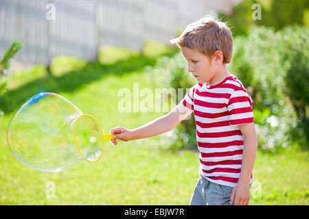 sympathische junge Seifenblasen im Garten Stockfoto