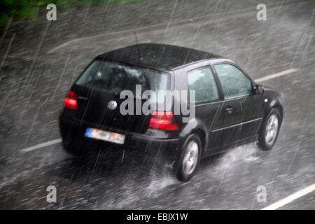 Auto auf der Straße bei starkem Regen, Essen, Ruhrgebiet, Nordrhein Westfalen, Deutschland Stockfoto