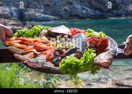 Hand der Kellnerin und Kellner mit frischen Meeresfrüchte-Platte, Mallorca, Spanien Stockfoto