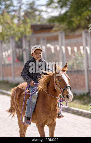 Ein junger mexikanischer Cowboy Herden Vieh hinunter eine Dorfstraße von mexikanischen Cowboys 5. November 2014 in beherbergt, Mexiko. Stockfoto