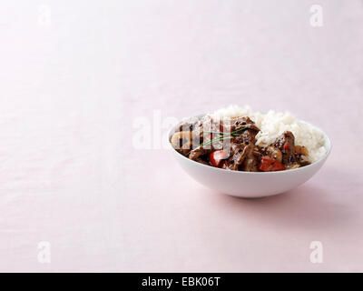 Schüssel mit Wok gebraten Rindfleisch in schwarzer Bohnensauce mit gedünstetem Reis Stockfoto