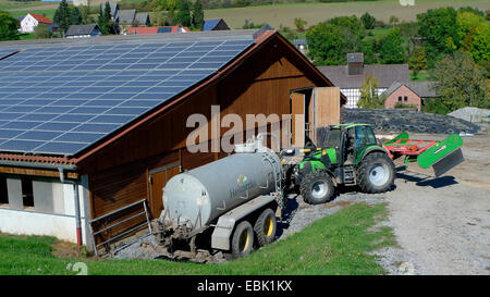 Sonnenkollektoren auf dem Dach eines landwirtschaftlichen Gebäudes, Deutschland Stockfoto