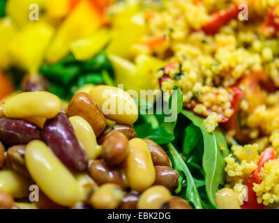 Gesunde lebendige Salat von gemischten, braune und gelbe Bohnen mit wilde Rauke, Paprika und Couscous. Stockfoto