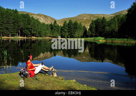 weibliche Wanderer ruht am Seeufer des Lac de Creno, Frankreich, Korsika, Soccia Stockfoto