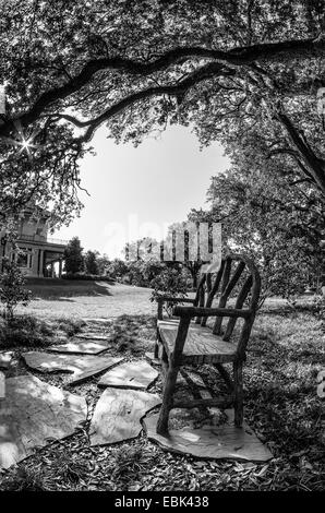 Bank und draußen Büchergestell in einem Park von Milton H letztere Memorial Library in The Garden District New Orleans LA USA Stockfoto