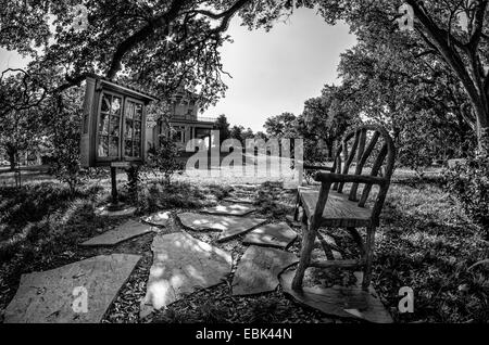 Bank und draußen Büchergestell in einem Park von Milton H letztere Memorial Library in The Garden District New Orleans LA USA Stockfoto