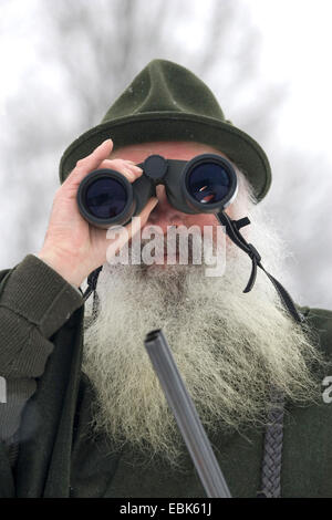 weißen bärtigen Jäger Blick durch ein Fernglas, Deutschland Stockfoto