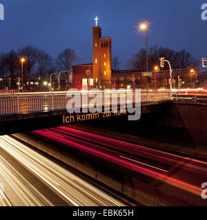 Autobahn A40 mit hellen Streifen und Brücke mit der Aufschrift "Ich Komm Zur Ruhe - bekomme ich etwas Ruhe" im Abendlicht, Bochum, Ruhrgebiet, Nordrhein-Westfalen, Deutschland Stockfoto