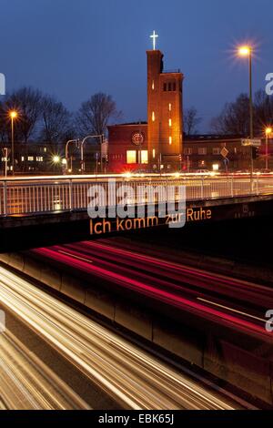 Autobahn A40 mit hellen Streifen und Brücke mit der Aufschrift "Ich Komm Zur Ruhe - bekomme ich etwas Ruhe" im Abendlicht, Bochum, Ruhrgebiet, Nordrhein-Westfalen, Deutschland Stockfoto