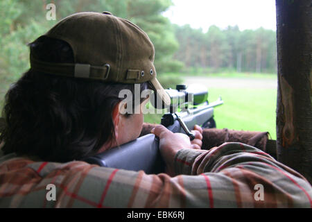 Huntsman am Stand heben ein Gewehr, Deutschland, Niedersachsen Stockfoto