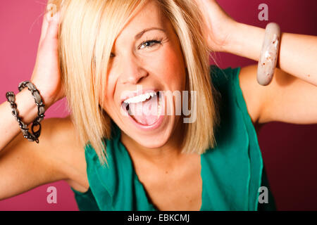 junge Frau hält ihren Kopf schreien frolicly Stockfoto