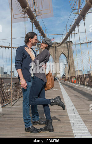 USA, New York State, New York City, Brooklyn, glückliche Paar auf der Brooklyn Bridge umarmen Stockfoto