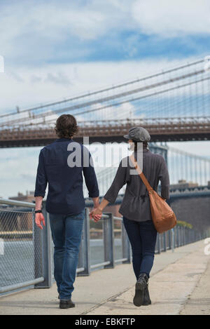 Hinten, Brooklyn, New York State, New York City, USA Anzeigen des Paares zu Fuß auf der Promenade, Brooklyn Bridge im Hintergrund Stockfoto