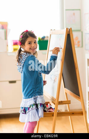 Porträt eines Mädchens (6-7) schreiben an Bord im Klassenzimmer Stockfoto