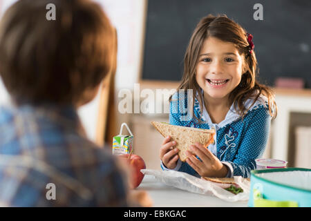 Schüler (6-7) Essen Mittagessen im Klassenzimmer Stockfoto