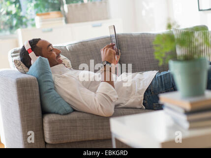 Mann auf Sofa mit TabletPC Stockfoto