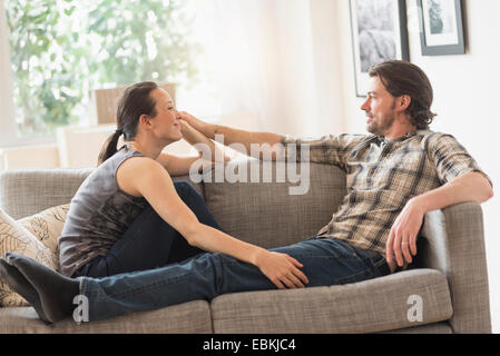 Fröhliches paar entspannende auf sofa Stockfoto