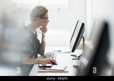 Seitenansicht des Business-Frau, die auf Desktop-pc im Büro arbeiten Stockfoto