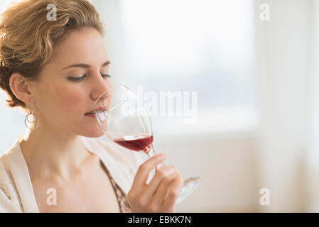 Junge Frau trinkt Rotwein Stockfoto