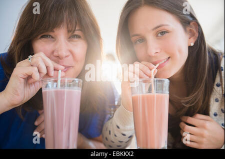 Porträt von Mutter und Tochter trinken Milchshakes (14-15) Stockfoto